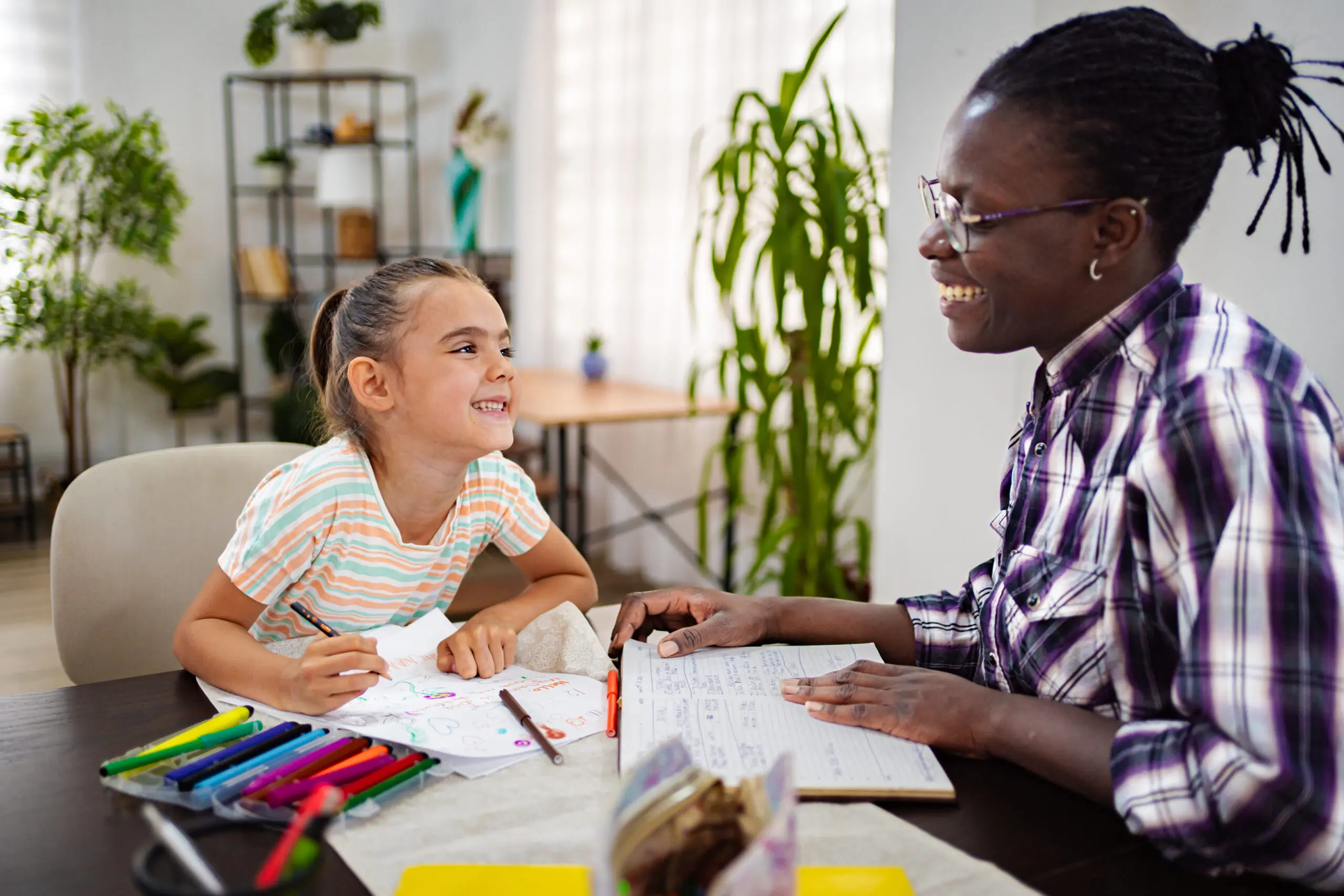 A child drawing with support from an adult