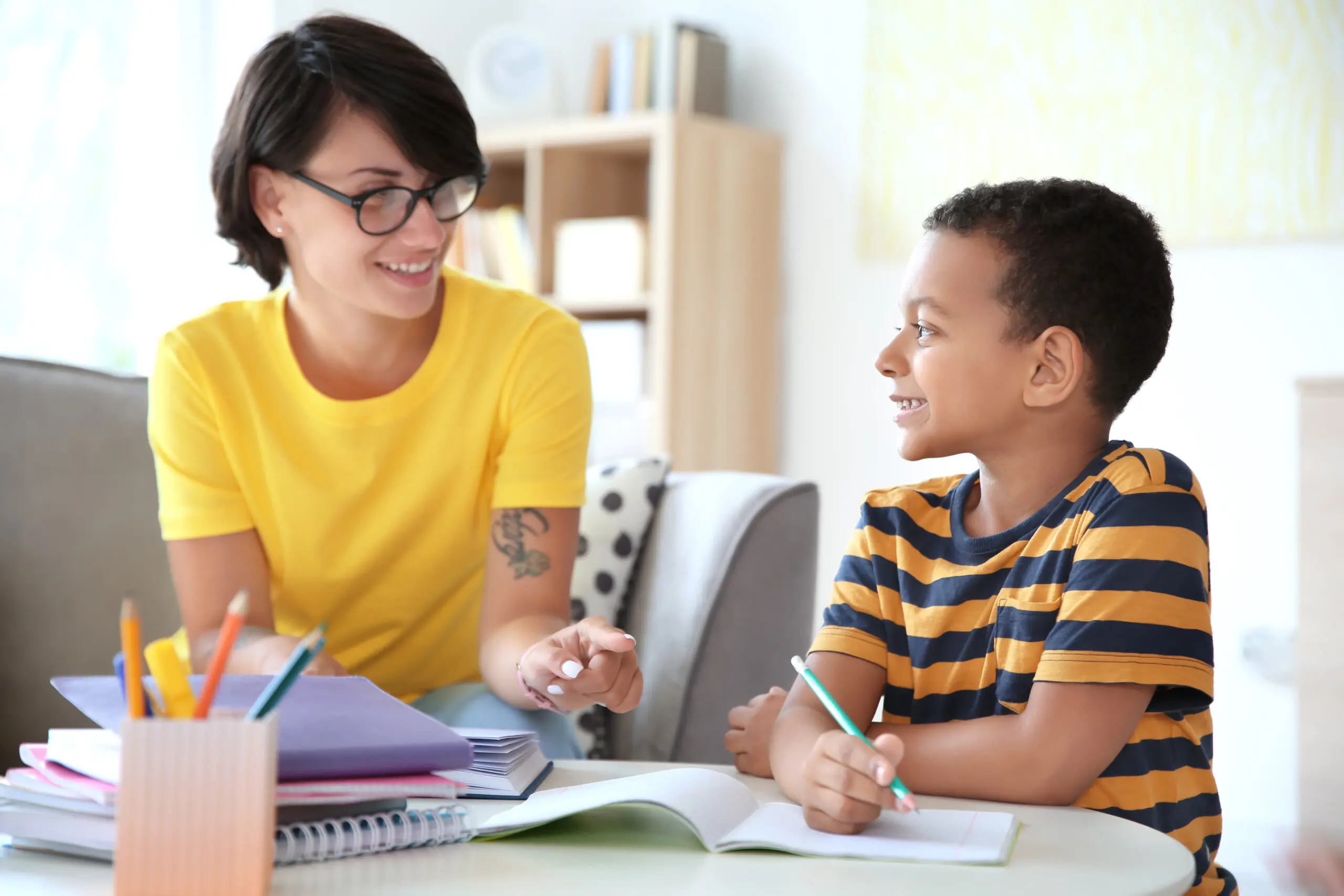 A caregiver helping a child with schoolwork at home
