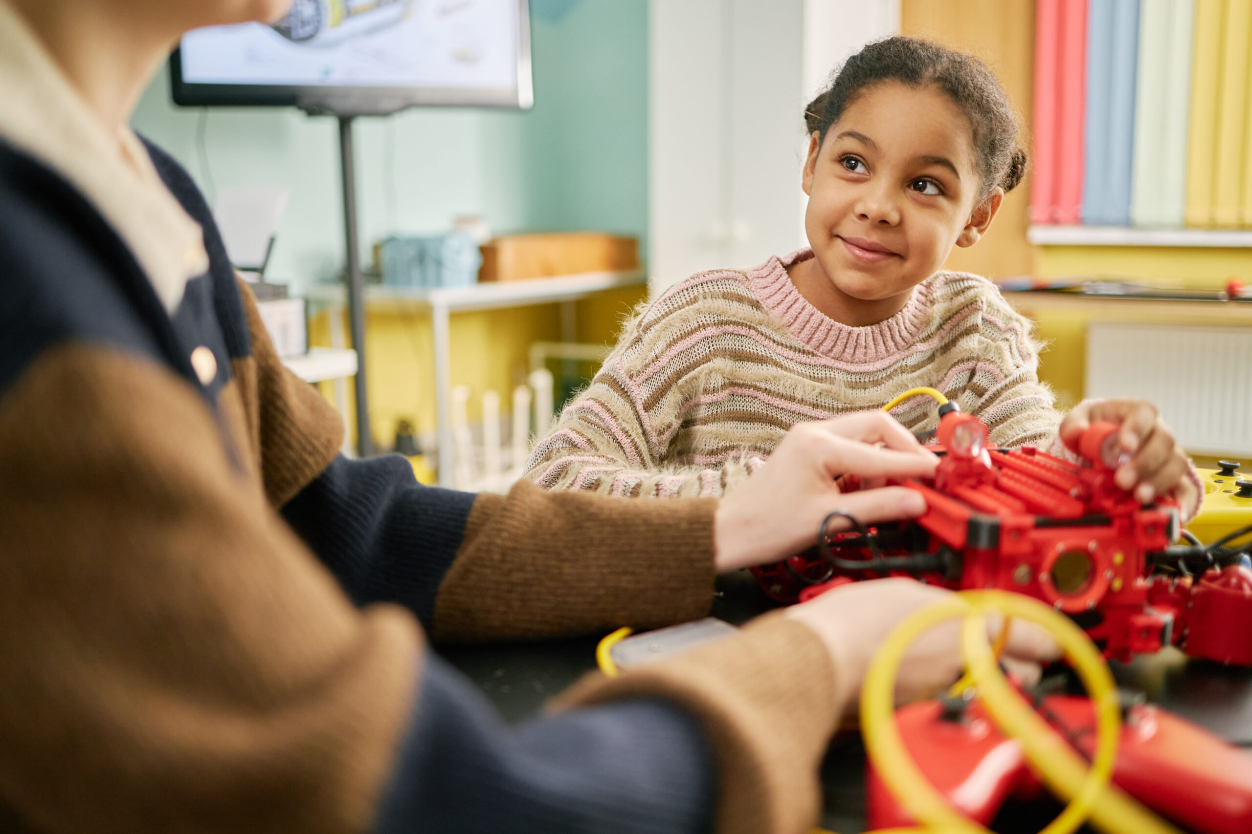 A child learning with support from an adult