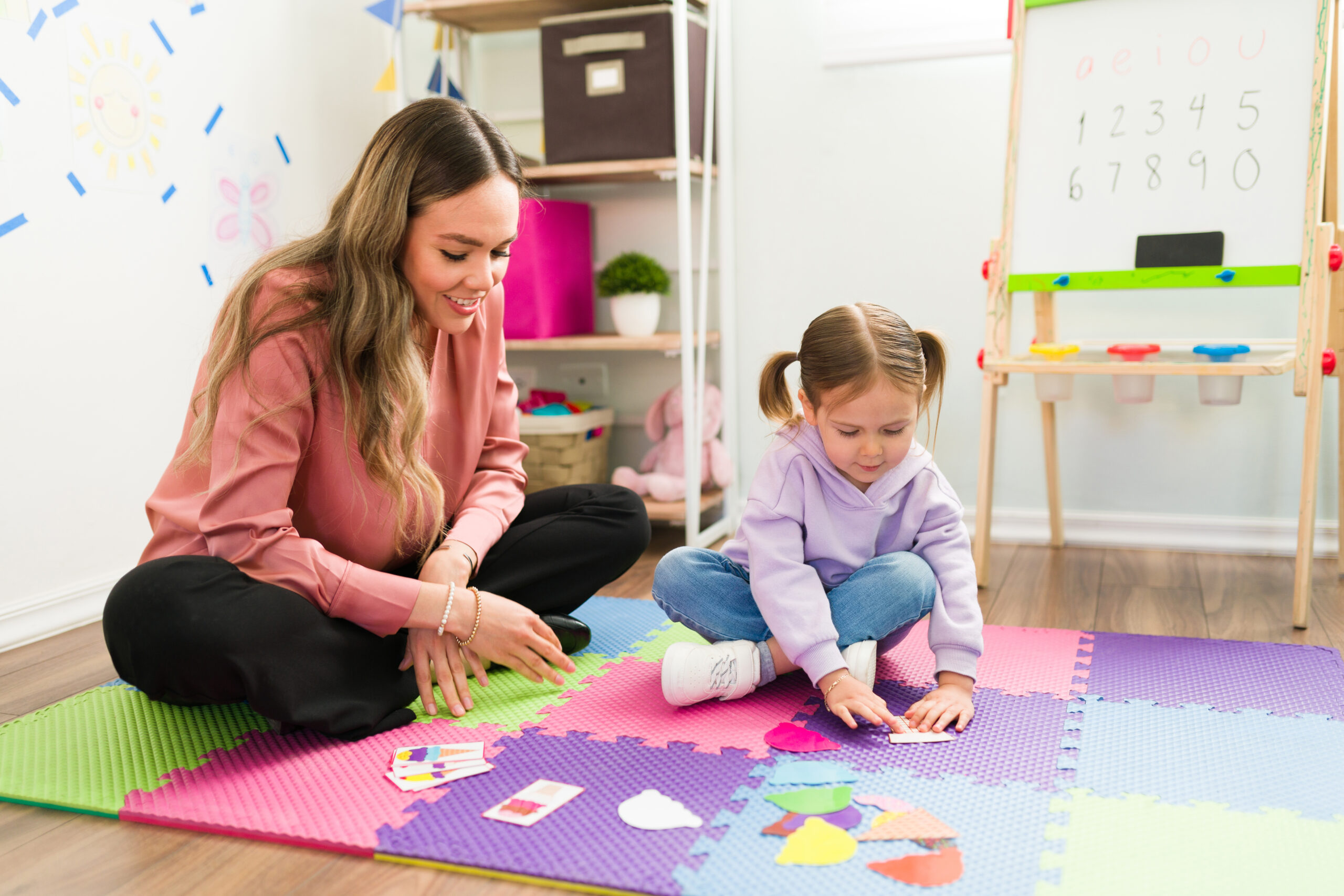 A child completing a puzzle with a therapist