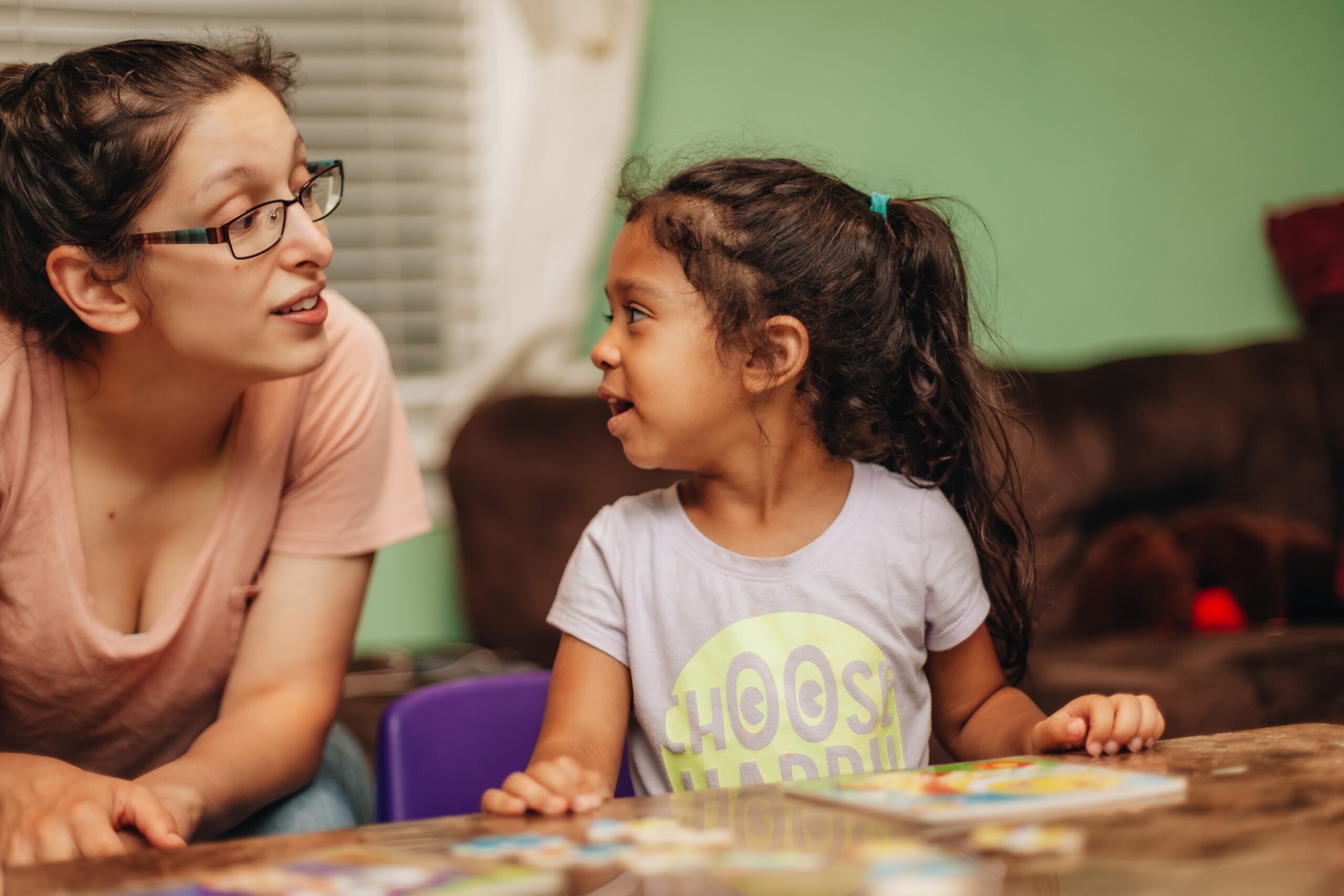 A child and adult working on a puzzle together